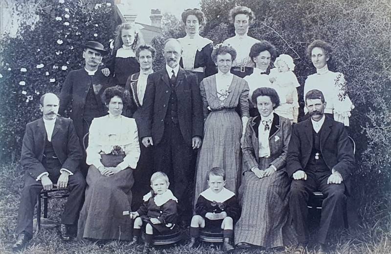 Ness Oliver (nee Shute) attends wedding of sister-in-law Ada Oliver on 25 August 1909. Ness is seen holding her baby Alex. Her little boy, Ivor, is seated front left. All names in next photo.